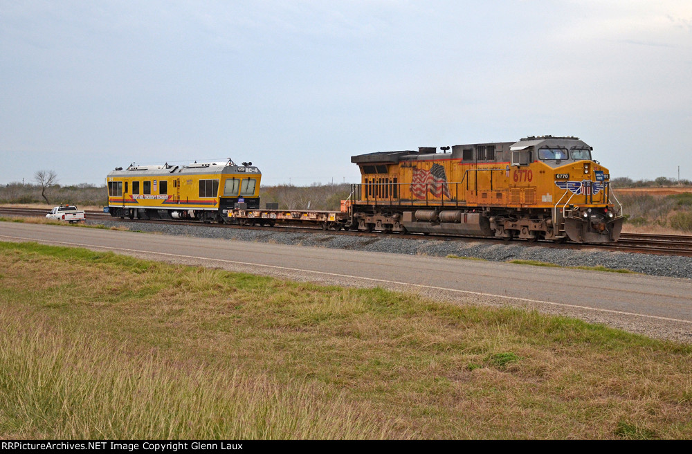 UP 6770 sits in a short siding hooked to a SOO Line flat car and UP EC-4